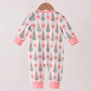 A baby long-sleeve footless jumpsuit hanging on a wooden hanger, featuring a white background with a repeating pattern of gray pine trees and pink bows, finished with pink ribbed cuffs and hem.