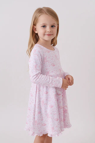 Young girl wearing a pink dress with a subtle pattern on a light gray background