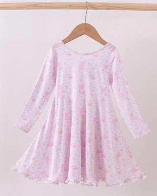 Pink floral dress on a wooden hanger against a white background