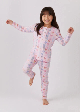 Child wearing a princess bow print  pajama set on a white background