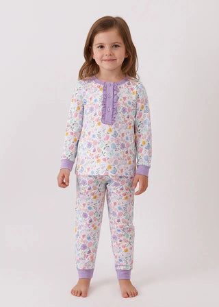 Young girl wearing a floral pajama set with purple accents on a white background