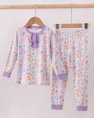 Floral pajama set with purple accents on a wooden hanger against a white background