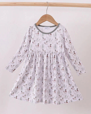 White dress with duck pattern on a wooden hanger against a white background