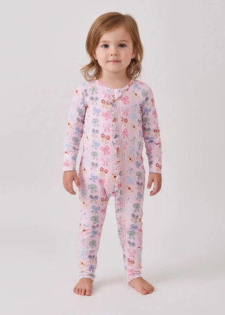 Child wearing a pink floral onesie on a white background