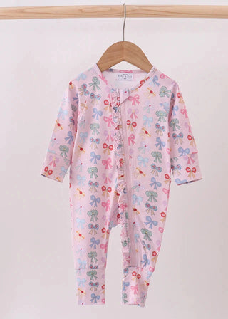 Baby onesie with colorful bow pattern on a hanger against a white background