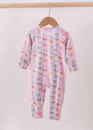 Children's onesie with floral pattern on a wooden hanger against a white background