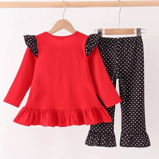 A toddler girl's two-piece outfit set consisting of a bright red long-sleeve top with black polka-dot ruffle shoulder details and a matching pair of black polka-dot pants, displayed on wooden hangers against a white background.
