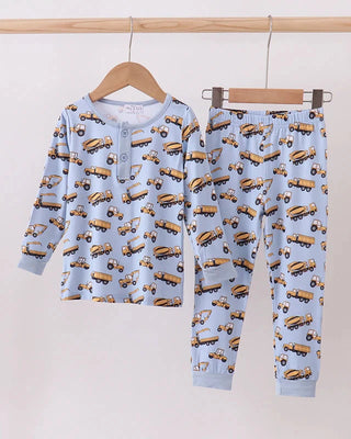 Children's pajama set with truck pattern on a hanger against a light background