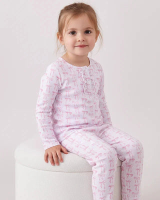 Child wearing pink pajamas with a pattern on a white background