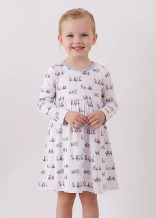 Young girl wearing a patterned dress on a plain background