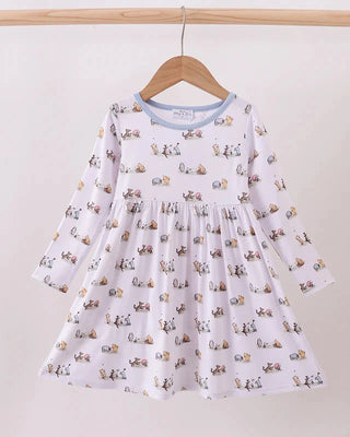 White dress with animal print hanging on a wooden hanger against a white background