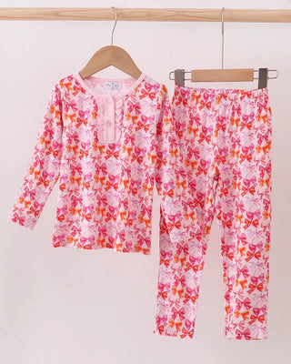 Children's pink floral pajama set on hangers against a white background