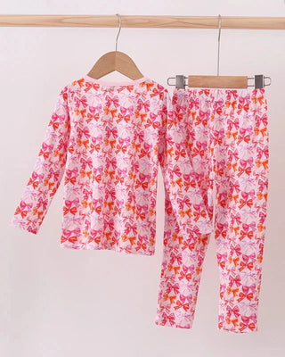 Children's pajama set with pink and orange butterfly pattern on a white background