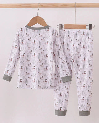 Children's pajama set with animal pattern on a hanger against a white background