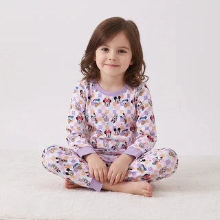 Child wearing a colorful pajama set with cartoon characters on a white background