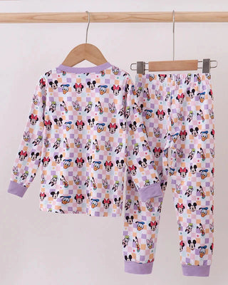 Children's pajama set with cartoon character pattern on a hanger against a white background
