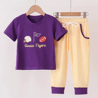 A two-piece children's outfit set hanging on wooden hangers against a light background. The set includes a purple short-sleeve t-shirt with a 'Geaux Tigers' football graphic and yellow-and-white gingham checkered pants with purple cuffs and pocket trim.