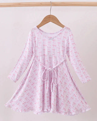 Pink dress with a subtle pattern on a wooden hanger against a white background