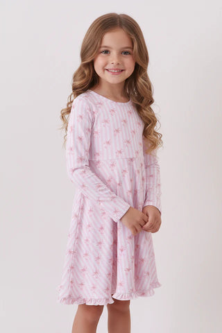 Young girl wearing a pink floral nightgown against a white background