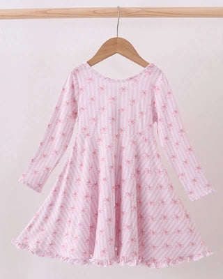 Pink dress with floral pattern on a wooden hanger against a white background
