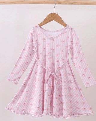 Pink floral dress on a hanger against a white background