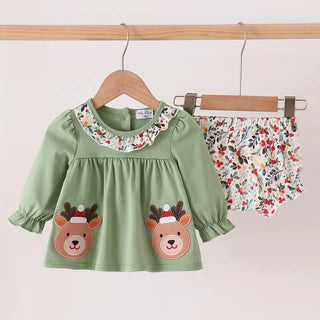 A baby girl's two-piece outfit hanging on wooden hangers against a plain light background. The set includes a sage green long-sleeve top with a floral ruffled collar, two embroidered reindeer faces on the front, and matching floral bloomers.