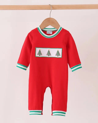 A baby red long-sleeve footless romper hanging on a wooden hanger, featuring green and white striped trim on the collar, cuffs, and ankles, with a chest panel showing three small green Christmas trees.