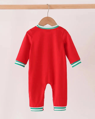 A bright red baby jumpsuit hanging on a wooden hanger from a light wood rod, featuring mint green and white striped trim at the collar, cuffs, and hem.