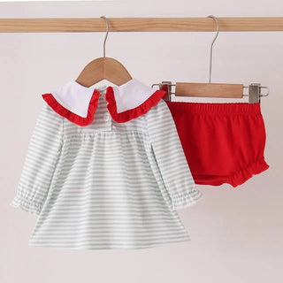 A baby girl's two-piece outfit set hanging on wooden hangers against a light beige wall. The set includes a long-sleeve top with white and light green horizontal stripes, a white Peter Pan collar with red ruffle trim, and matching solid red bloomers.