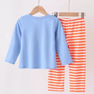 A children's two-piece outfit set hanging on wooden hangers against a plain light background. The set includes a light blue long-sleeve top and orange-and-white striped pants.