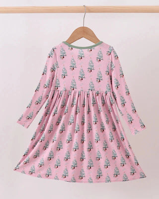 Pink dress with tree pattern on a hanger against a light pink background
