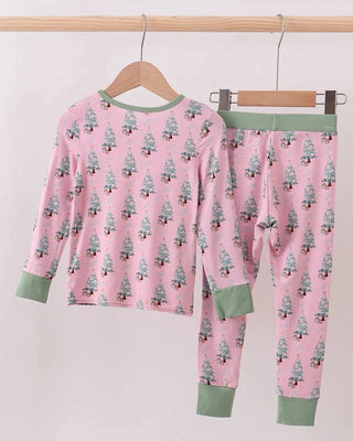 Pink pajama set with tree pattern on hangers against a white background