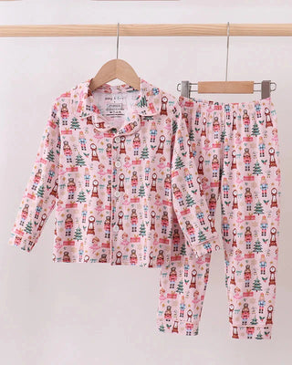 Children's pajama set with nutcracker pattern on a hanger against a white background
