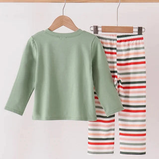 A children's two-piece outfit hanging on wooden hangers against a plain light background. The set includes a sage green long-sleeve top and striped pants with horizontal bands of red, orange, pink, gray, and white.