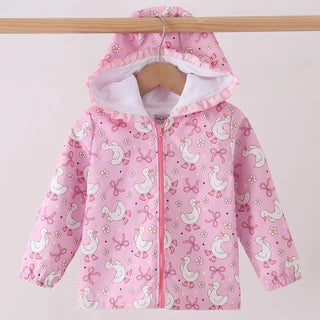 A pink hooded jacket with a white goose print, hanging on a wooden hanger from a wooden clothes rack against a light pink background.