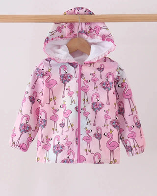 A pink hooded jacket with an allover flamingo print, hanging on a wooden hanger from a wooden clothes rack against a plain light background.