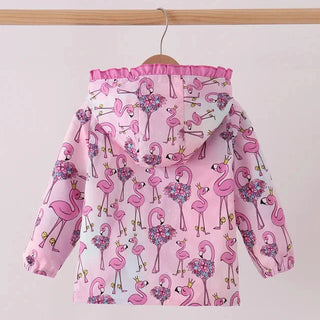 A pink hooded jacket with an allover flamingo print, hanging on a wooden hanger from a light wood rod against a plain light gray wall.