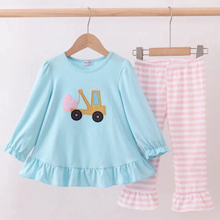 Children's outfit with blue top and pink striped pants on a hanger against a white background