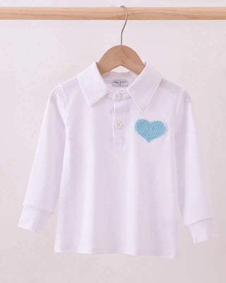 White shirt with a blue heart design on a hanger against a white background