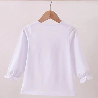 White blouse with ruffled sleeves on a wooden hanger against a beige background