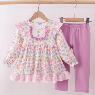 Children's outfit set with heart patterns on a white background