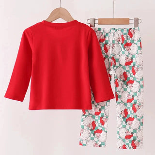 A children's two-piece clothing set hanging on wooden hangers against a plain light background. The set includes a solid bright red long-sleeve top and matching patterned pants with a white base, red and green motifs, and a green-and-white checkered border.