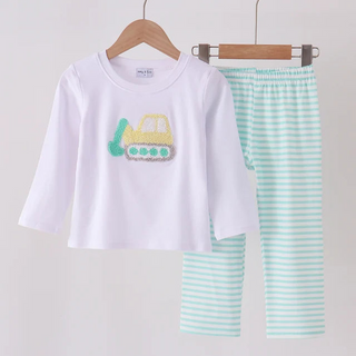 A children's two-piece pants set hanging on wooden hangers against a plain light background. The set includes a white long-sleeve top with a yellow and green construction truck graphic on the chest, and mint green and white horizontally striped pants.