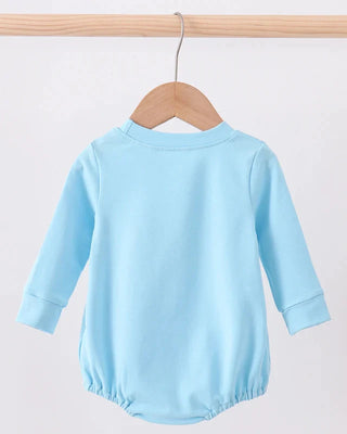 Light blue baby romper on a wooden hanger against a white background