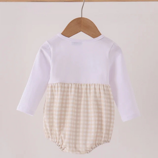 A baby long-sleeve romper hanging on a wooden hanger, featuring a solid white upper half and a cream and beige gingham checkered lower half.