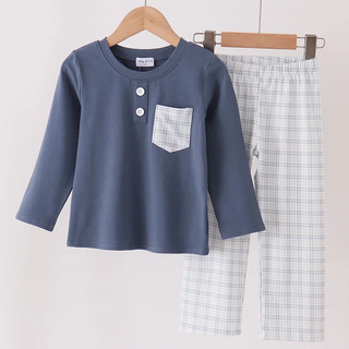 A children's two-piece clothing set hanging on wooden hangers against a plain light background. The set includes a slate blue long-sleeve henley top with a chest pocket and three buttons, paired with light blue and white plaid pants.