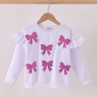 A white long-sleeve children's sweatshirt with ruffled shoulders and four pink sequined bow appliqués, hanging on a wooden hanger against a plain light background.