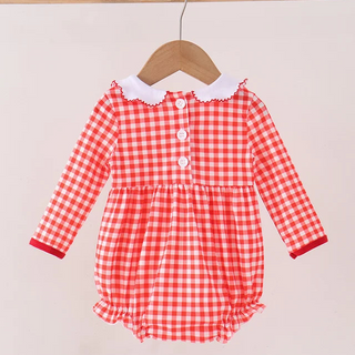 A baby long-sleeve romper in a red and white gingham check pattern, featuring a white ruffled Peter Pan collar and three white buttons down the front, hanging on a wooden hanger.
