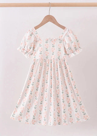Floral dress on a hanger against a plain background
