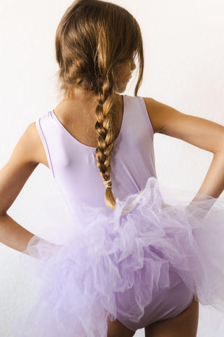 Young girl in a lavender ballet outfit with a white background